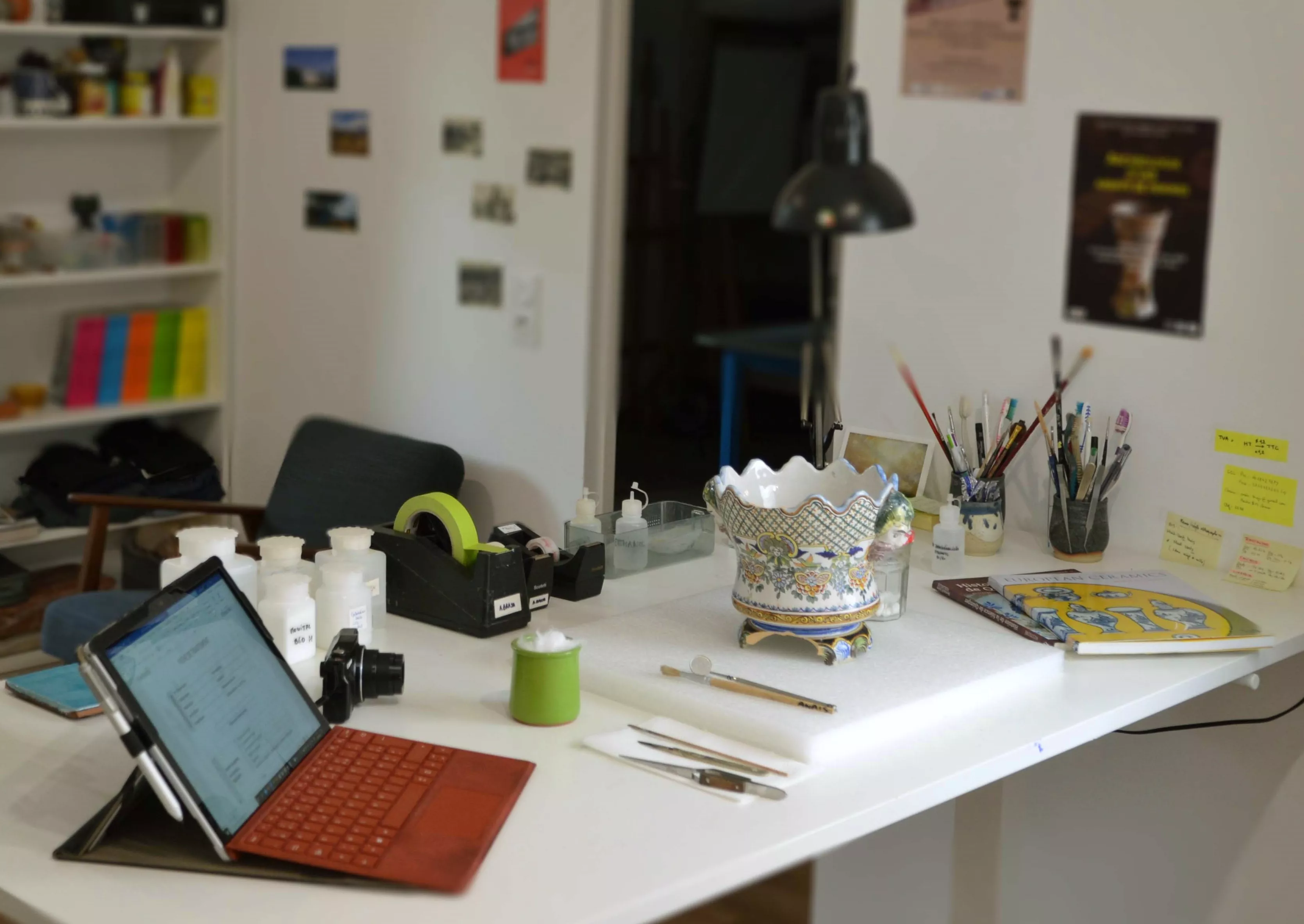 Vue d'un établi, vase en faïence en cours d'étude pour réaliser un constat d'état