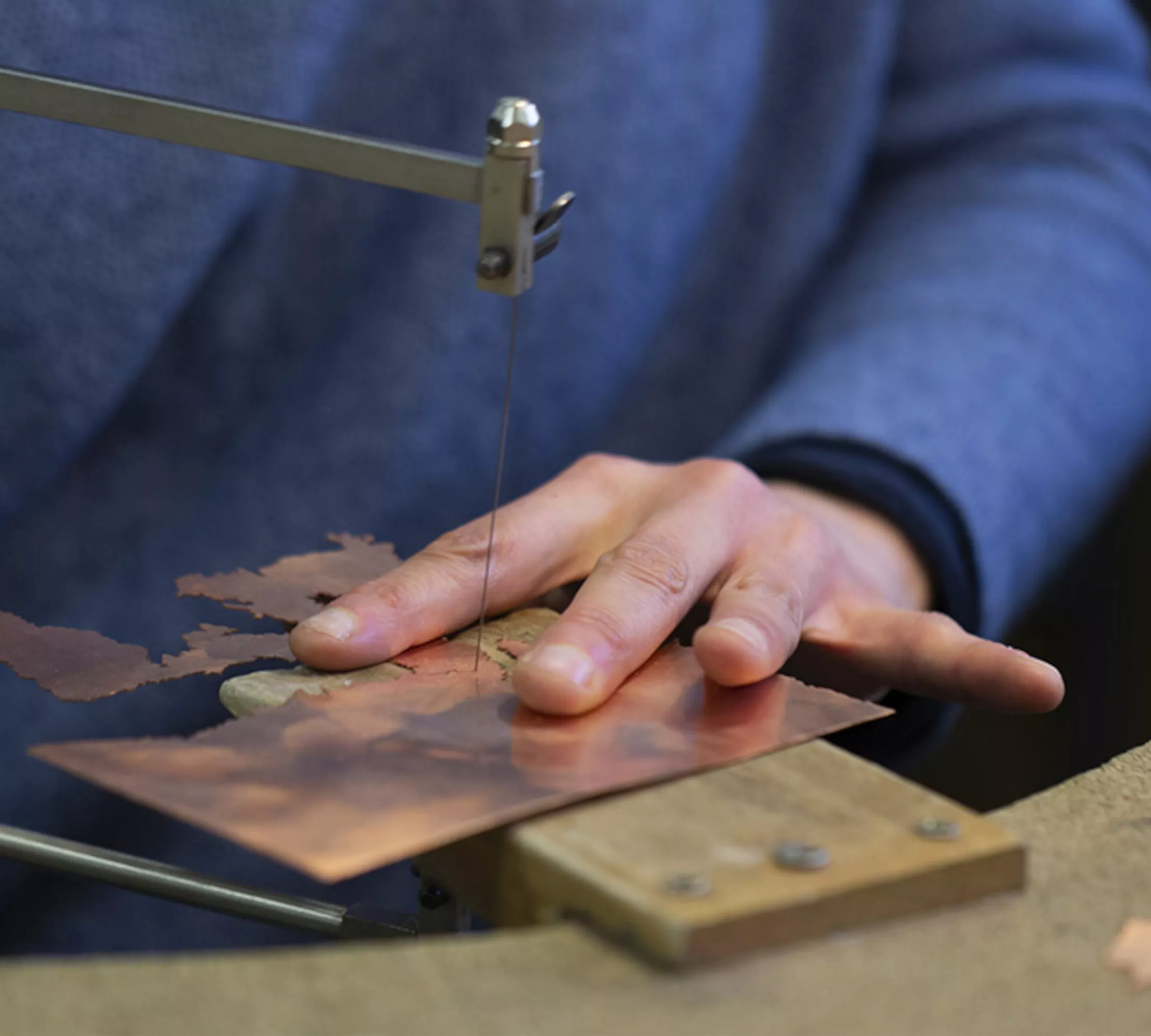 Découpe du cuivre à la scie de bijoutier pour une découpe précise avant l'émaillage.