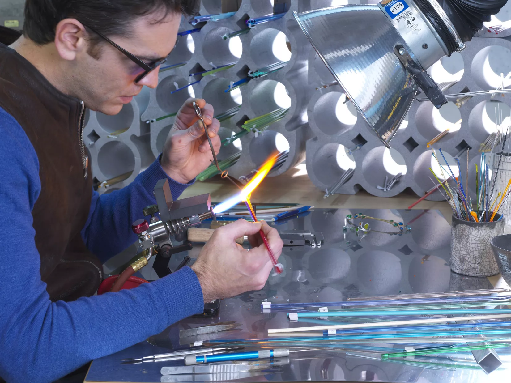 Benoit travaillant le verre au chalumeau pour les bijoux Beïad