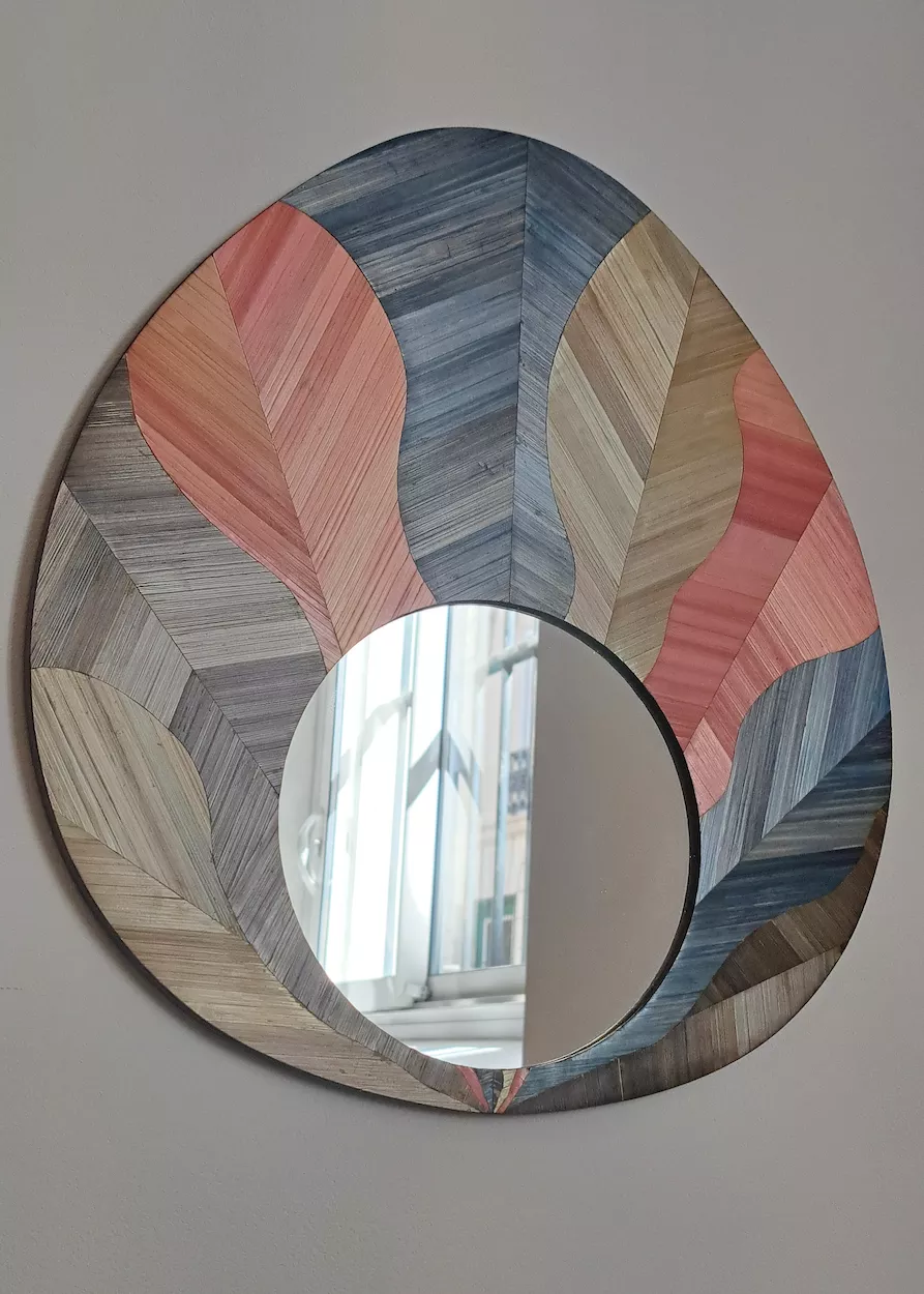 Miroir ovoïde décoré d'une marqueterie de paille aux motifs organiques