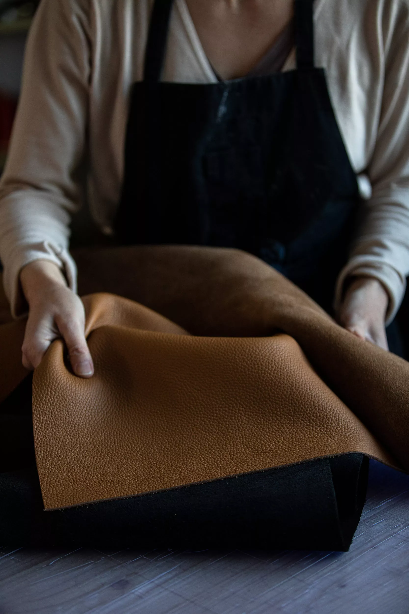 photo atelier avec maroquinier tenant du cuir haut de gamme provenant de la célèbre tannerie basque Carriat