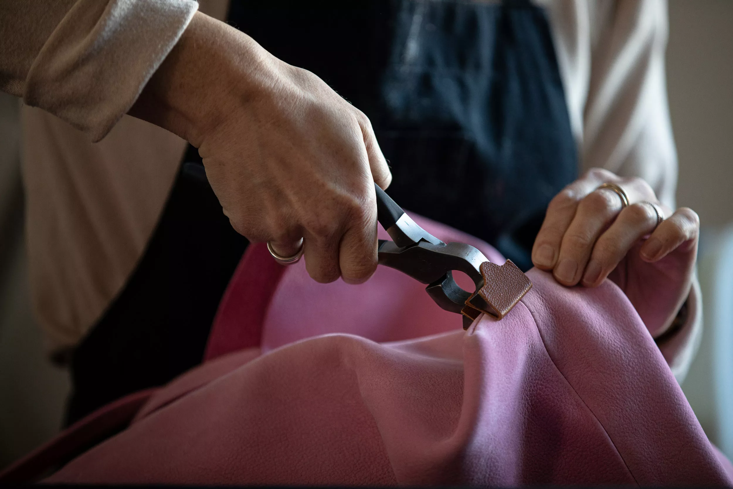 Travail de l'artisan maroquinier, mise en forme d'un sac en cuir avec outil pince. Savoir-faire traditionnel