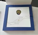 Intérieur du coffret Patrouille de France avec son livre et l'écusson de la patrouille incrusté dans la couverture.