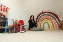 Fresque réalisée sur le mur d'une salle de jeu chez un particulier en Normandie, représentant un arc-en-ciel coloré