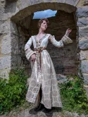 Noble femme dans sa robe brocardée dans un décors de pierre et de végétation