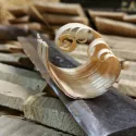 Copeau de châtaignier posé sur un outil de travail du bois nommé plane ou encore couteau à deux manches.